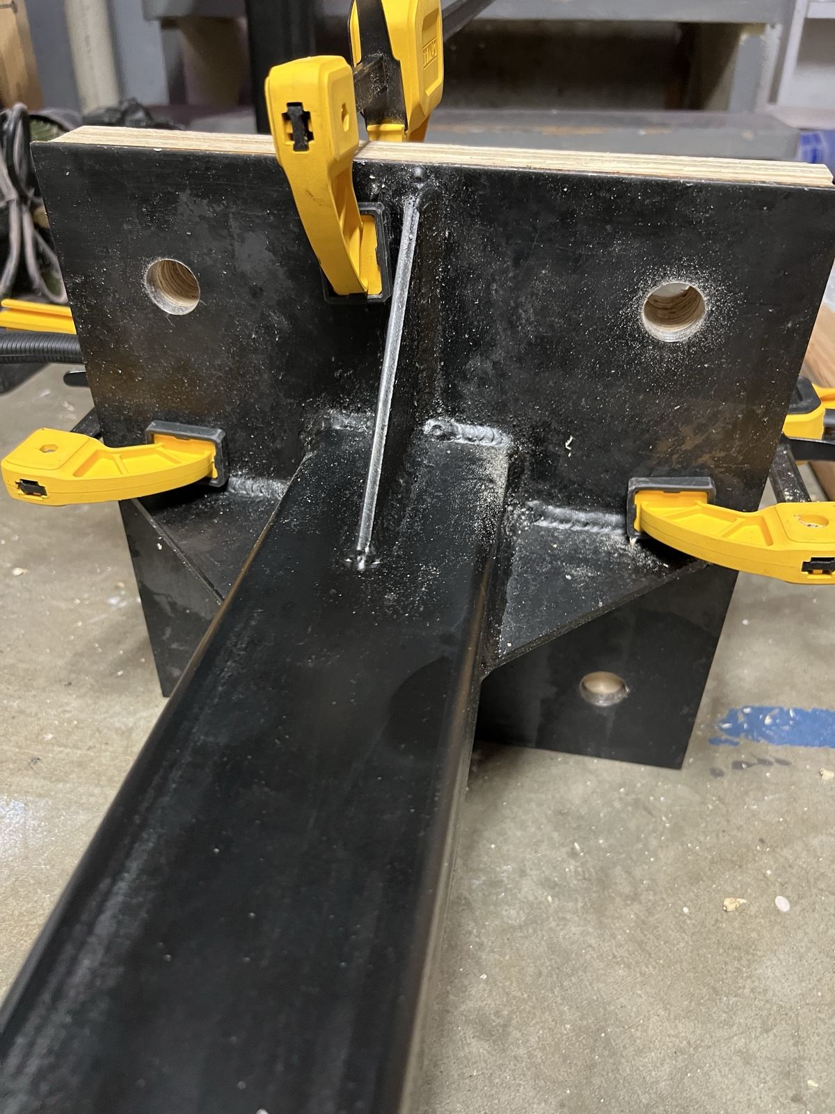 Mast welded to its steel base plate, clamped in the shop