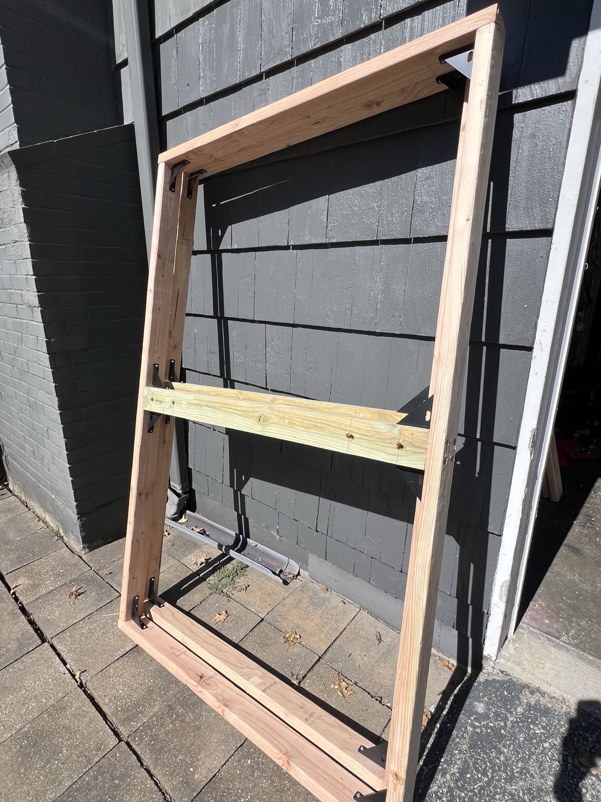 Assembled timber frame leaning against the house
